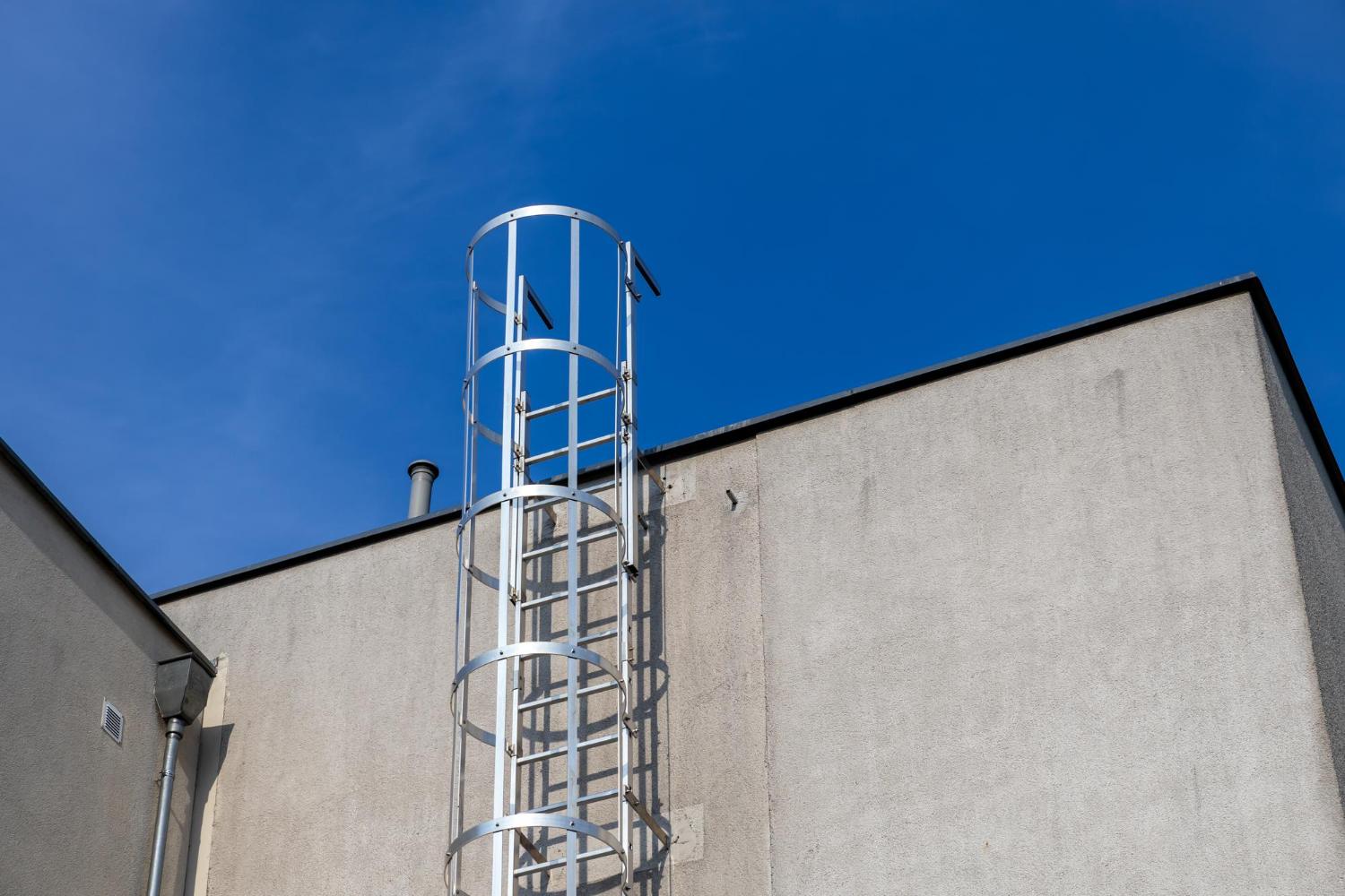 Fixed vertical ladder with safety cage to a flat roof